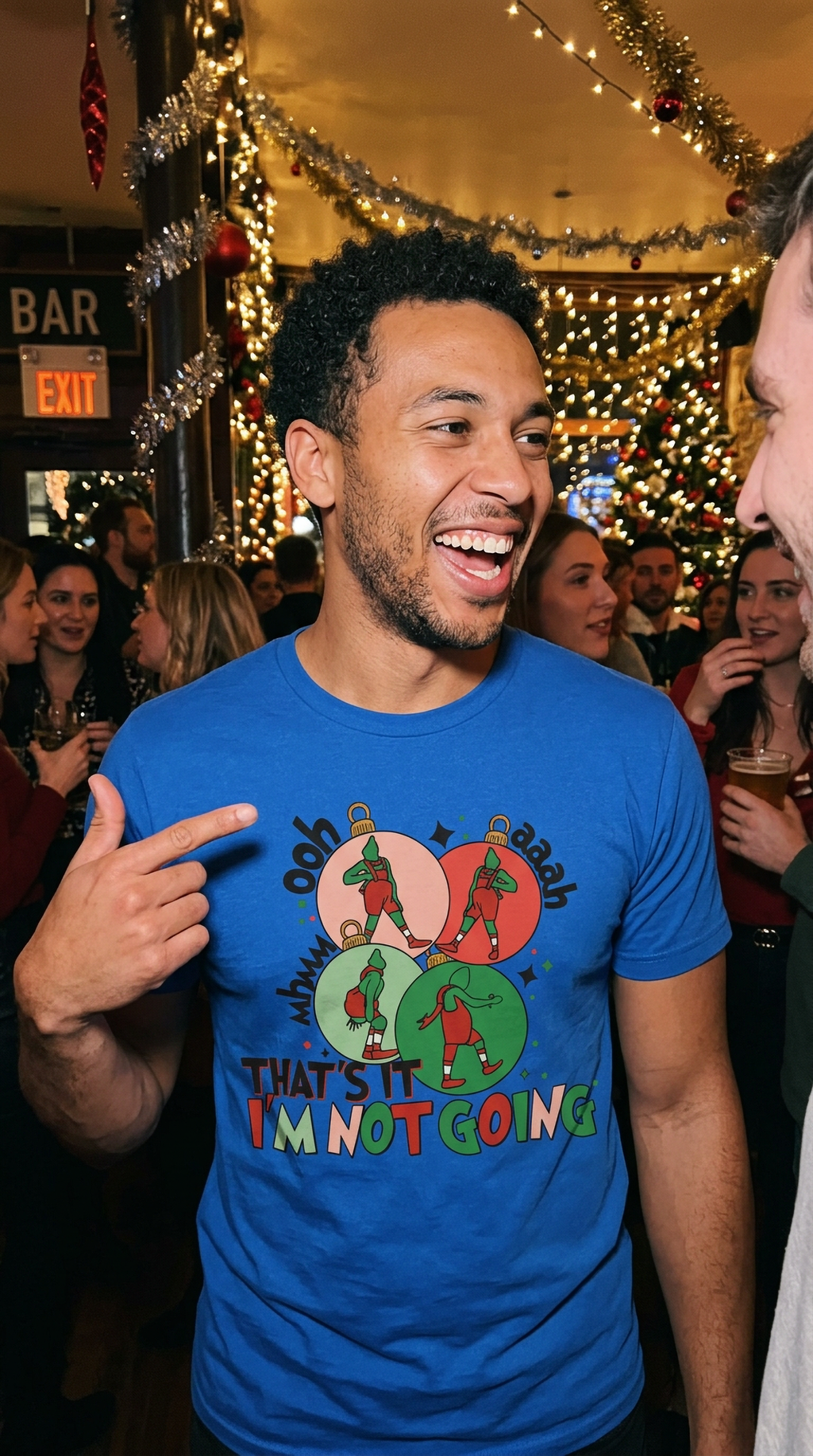 Blue Lifestyle: Man wearing a blue funny Grinch Christmas graphic t-shirt while standing near festive Christmas decorations.