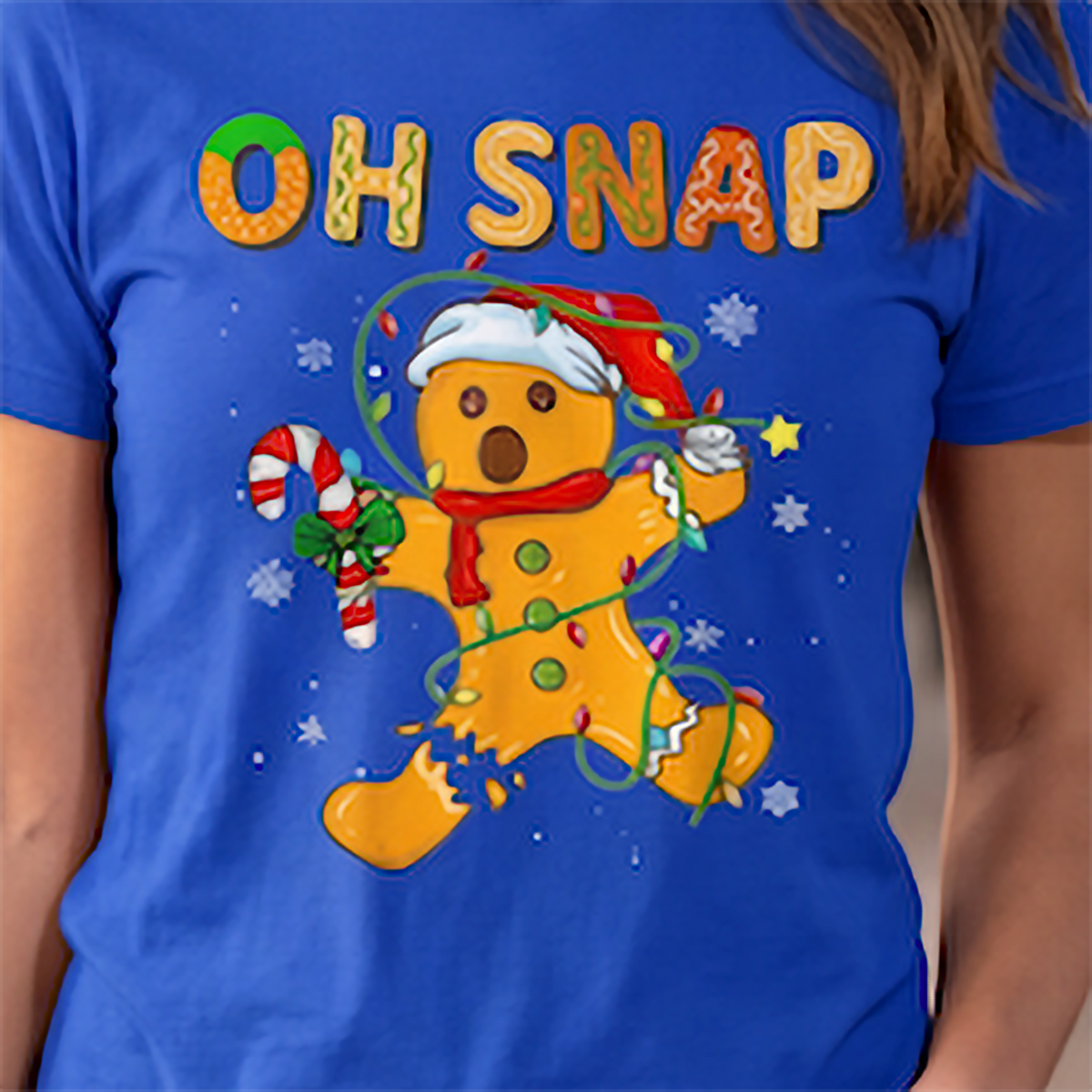 Close-up of Oh Snap gingerbread man Christmas design on blue shirt.