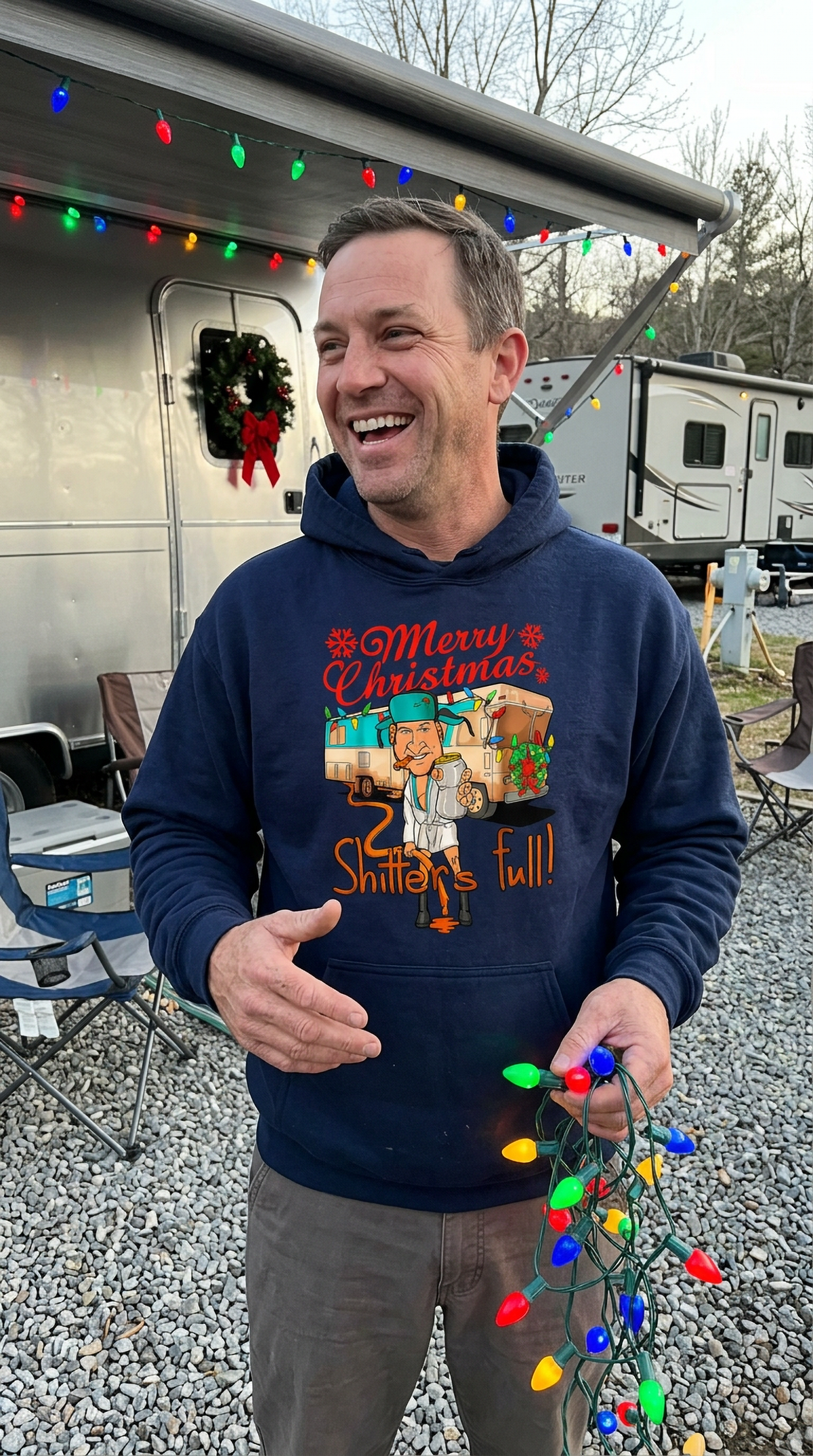 Man wearing navy blue Shitter’s Full Christmas Vacation hoodie outdoors