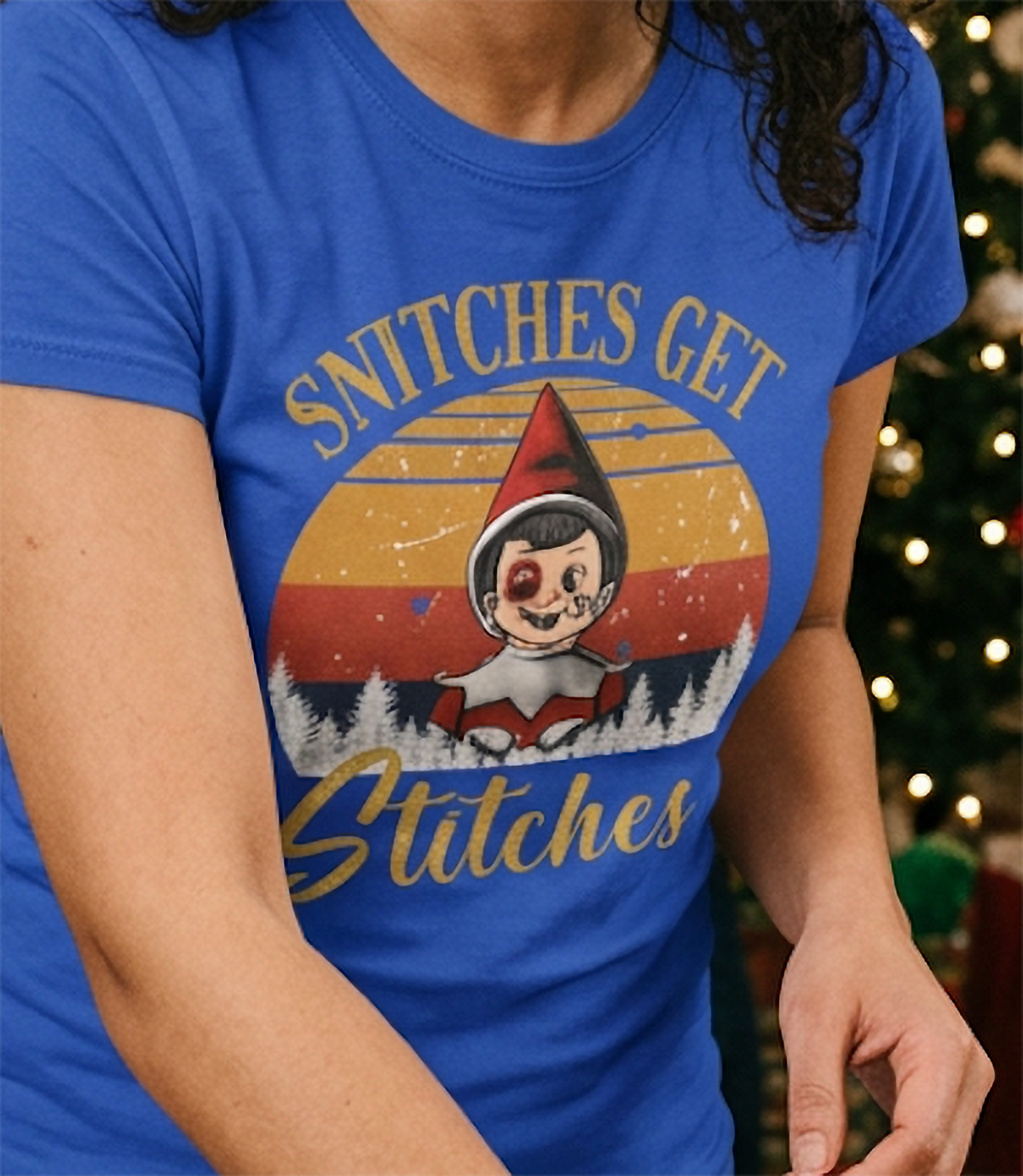Close-up of blue Snitches Get Stitches Christmas shirt worn at a festive holiday gathering.