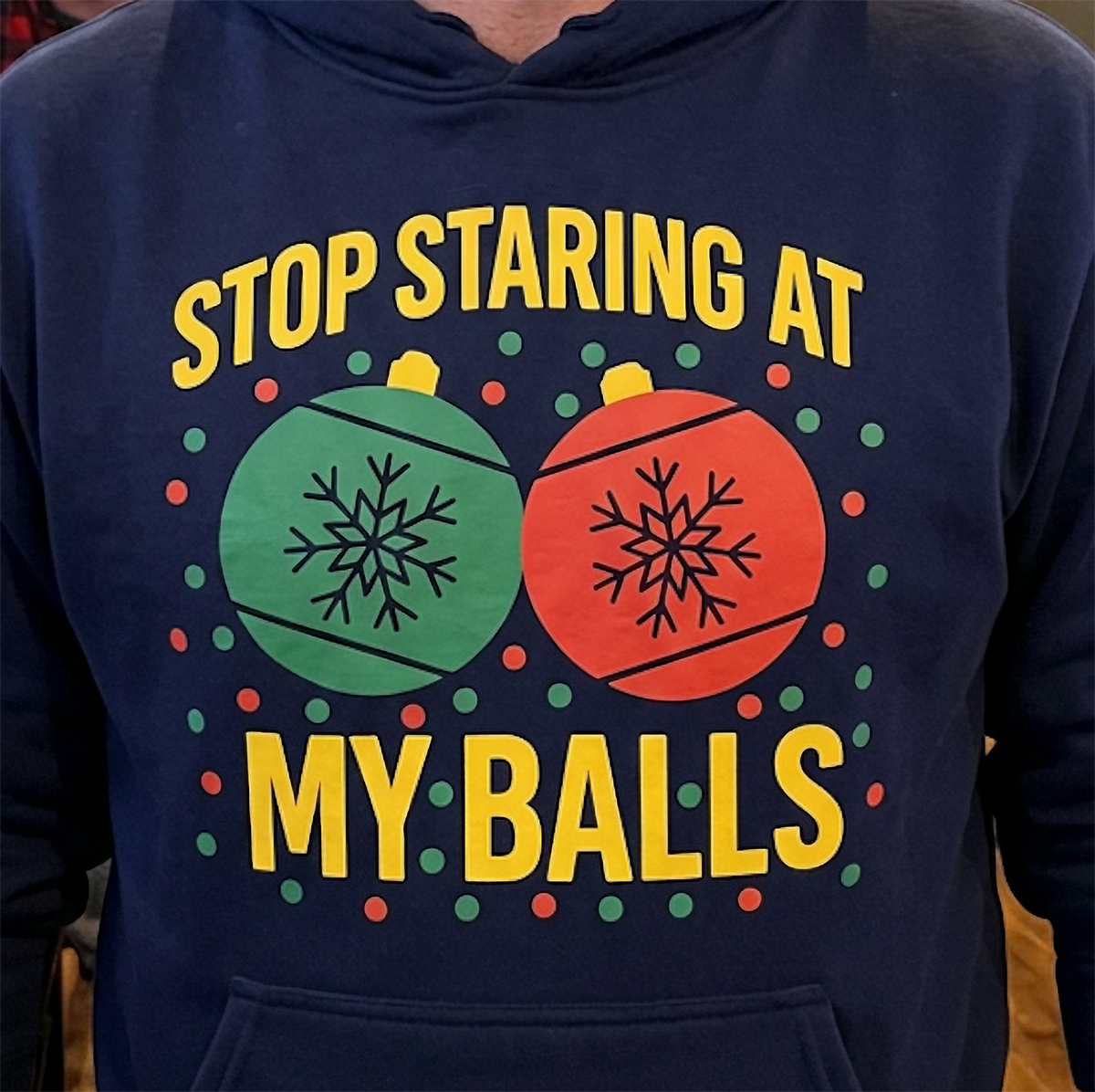 Close-up of Stop Staring at My Balls Christmas graphic on navy blue hoodie