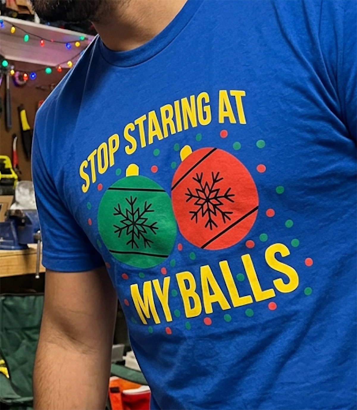 Close-up of blue Christmas ornament t-shirt showing sarcastic Stop Staring at My Balls holiday design.