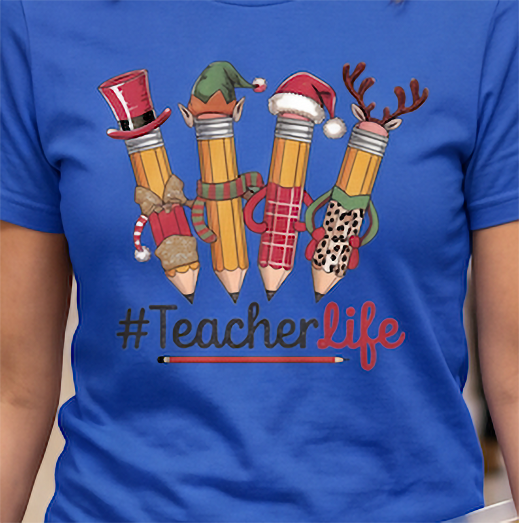 Close-up of royal blue Teacher Life Christmas shirt with festive character pencils and #TeacherLife lettering.