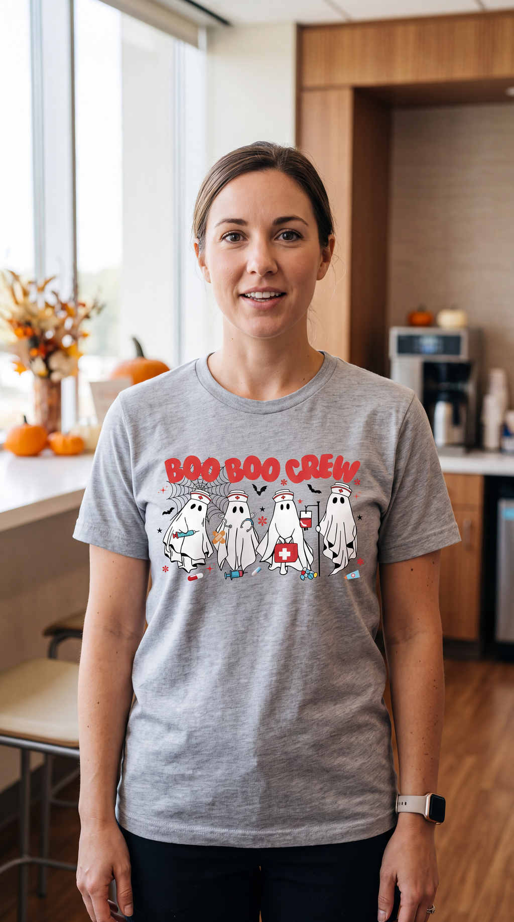 Woman wearing a heather gray nurse Halloween shirt with Boo Boo Crew ghosts and medical-themed spooky season design.