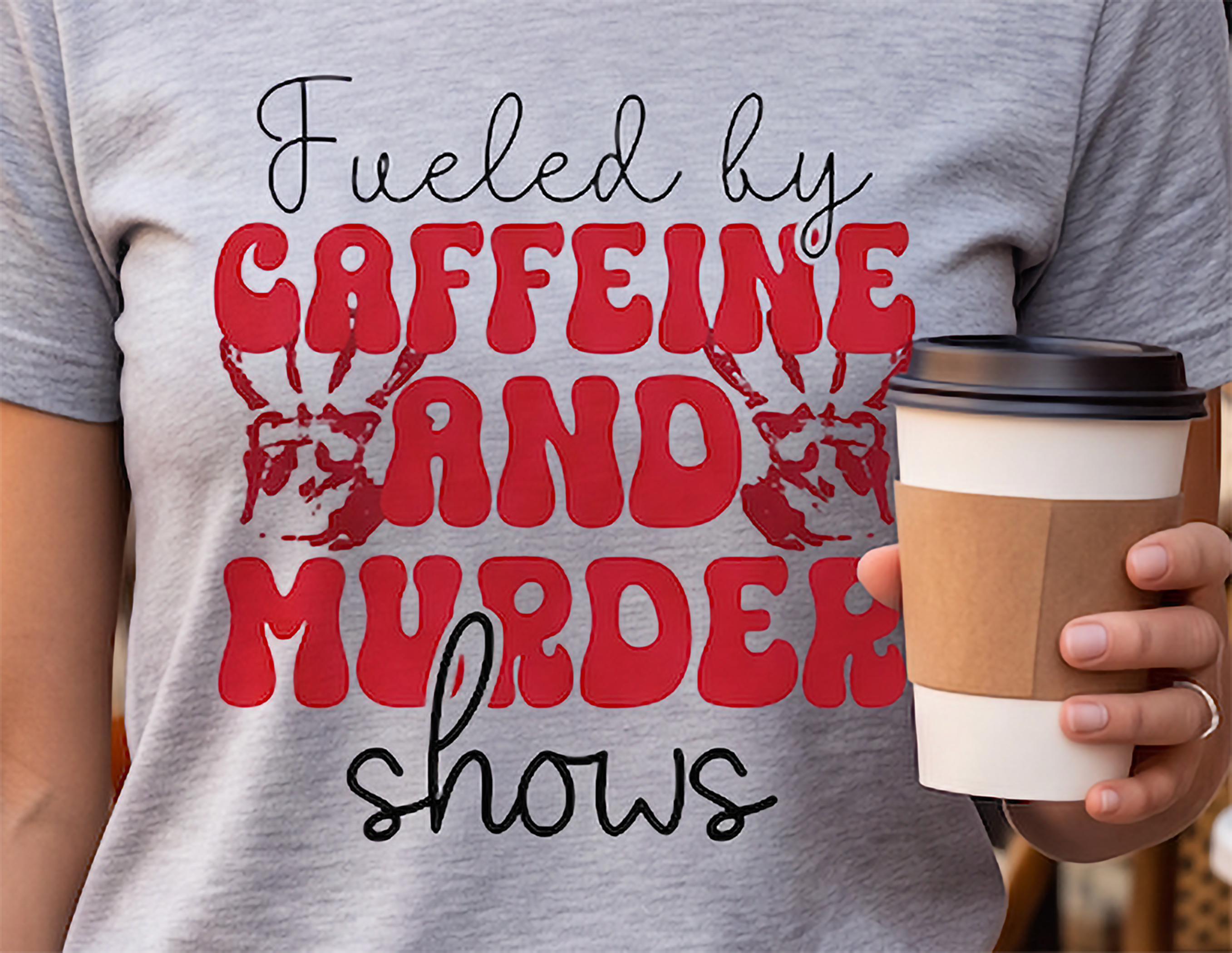 Close-up of Caffeine and Murder Shows true crime graphic with red retro lettering and bloody handprints on Heather Gray shirt
