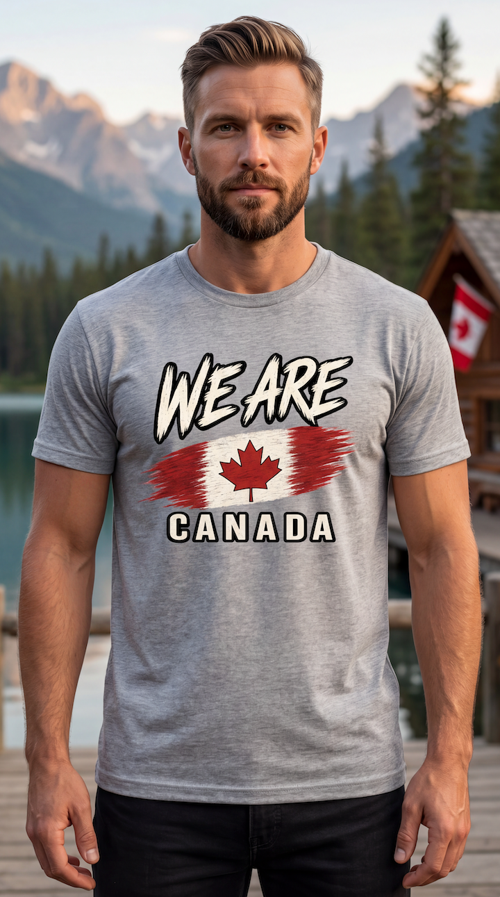 A man wearing a heather gray t-shirt with a graphic that reads 'WE ARE CANADA' and features a stylized Canadian flag, set against a scenic background of mountains, lakes, and a wooden cabin.