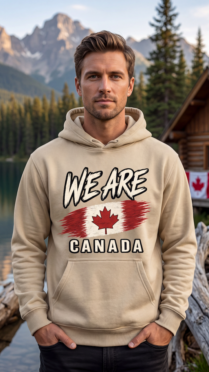 A man wearing a beige hoodie with a 'WE ARE CANADA' graphic featuring a stylized Canadian flag, posed in front of a scenic mountain and lake background.
