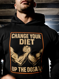 Man wearing black gym hoodie with “Up The Dosage” graphic in dark streetwear setting