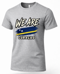 A heather gray short-sleeve t-shirt with a graphic print on the front. The design features the text 'WE ARE' in a white and black brush-stroke font above a stylized blue and yellow flag, and 'CURAÇAO' in white block letters below.