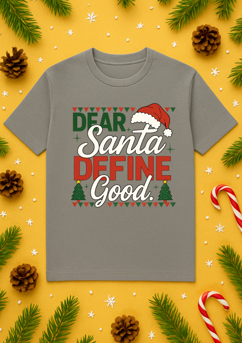 Gray “Dear Santa Define Good” Christmas T-shirt displayed on a yellow holiday background with pine branches, candy canes, pinecones, and snowflake decorations.