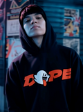 Person wearing black streetwear hoodie with DOPE ghost graphic design in urban setting