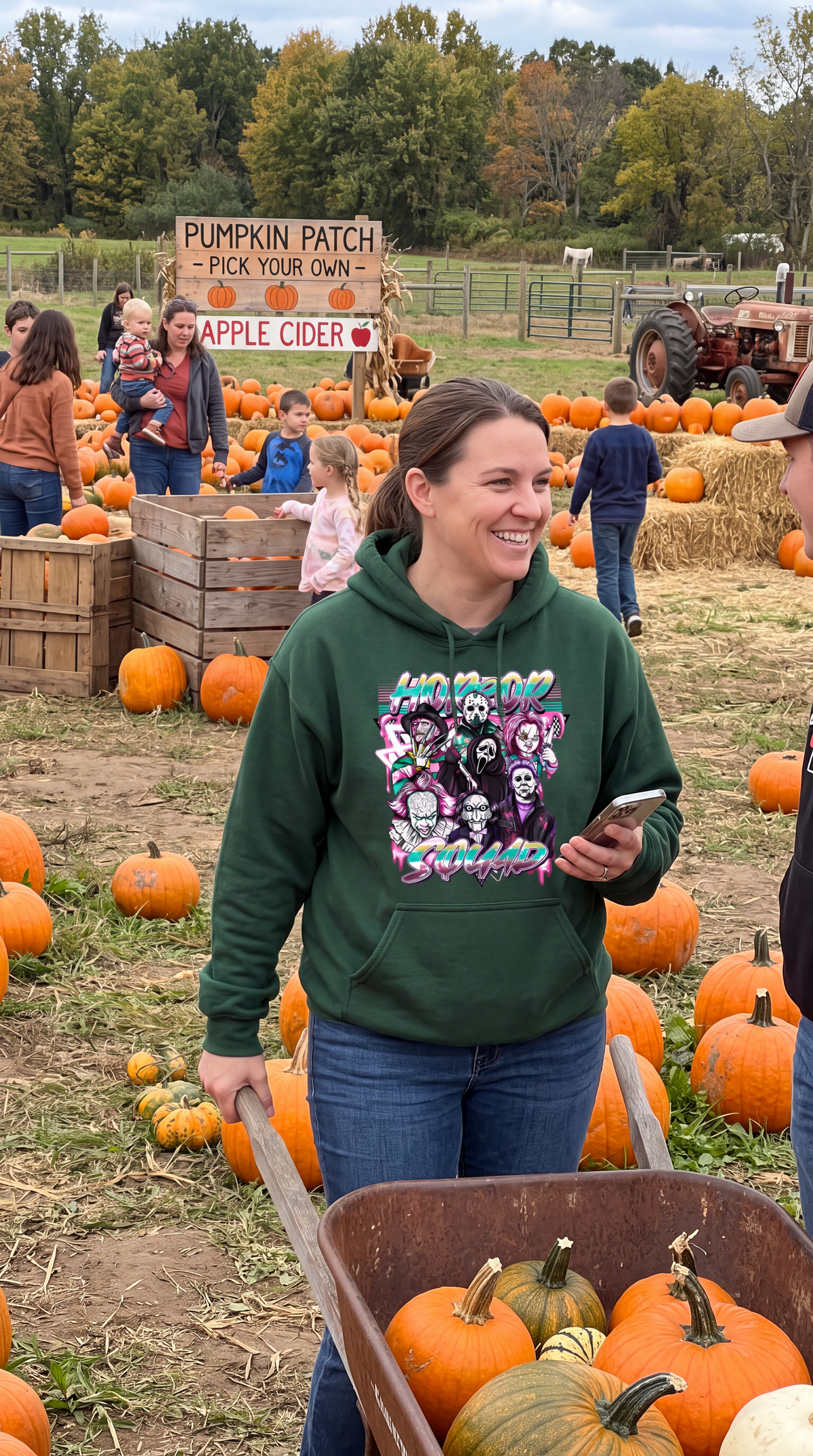 Woman wearing forest green Horror Squad hoodie with retro horror character graphic