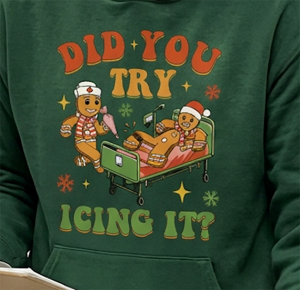 Close-up of Did You Try Icing It gingerbread graphic on forest green Christmas hoodie