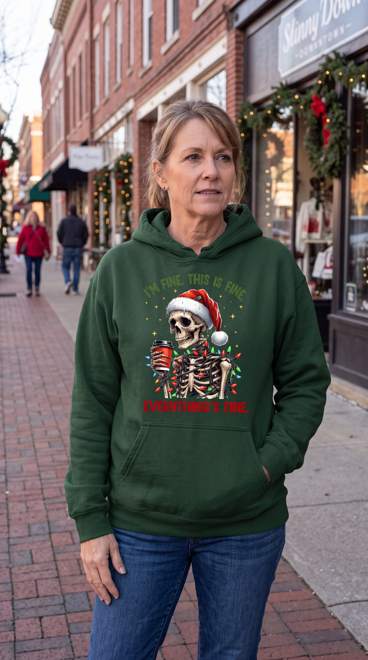 Woman wearing forest green Christmas skeleton hoodie with I’m Fine Everything’s Fine design