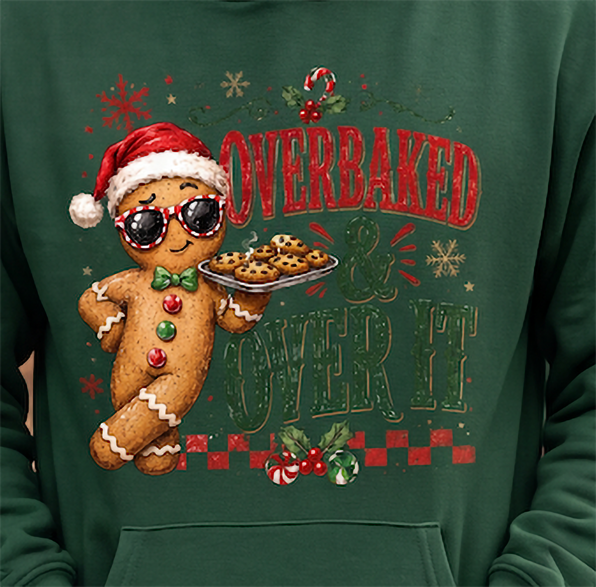 Close-up of forest green Overbaked and Over It gingerbread Christmas hoodie design