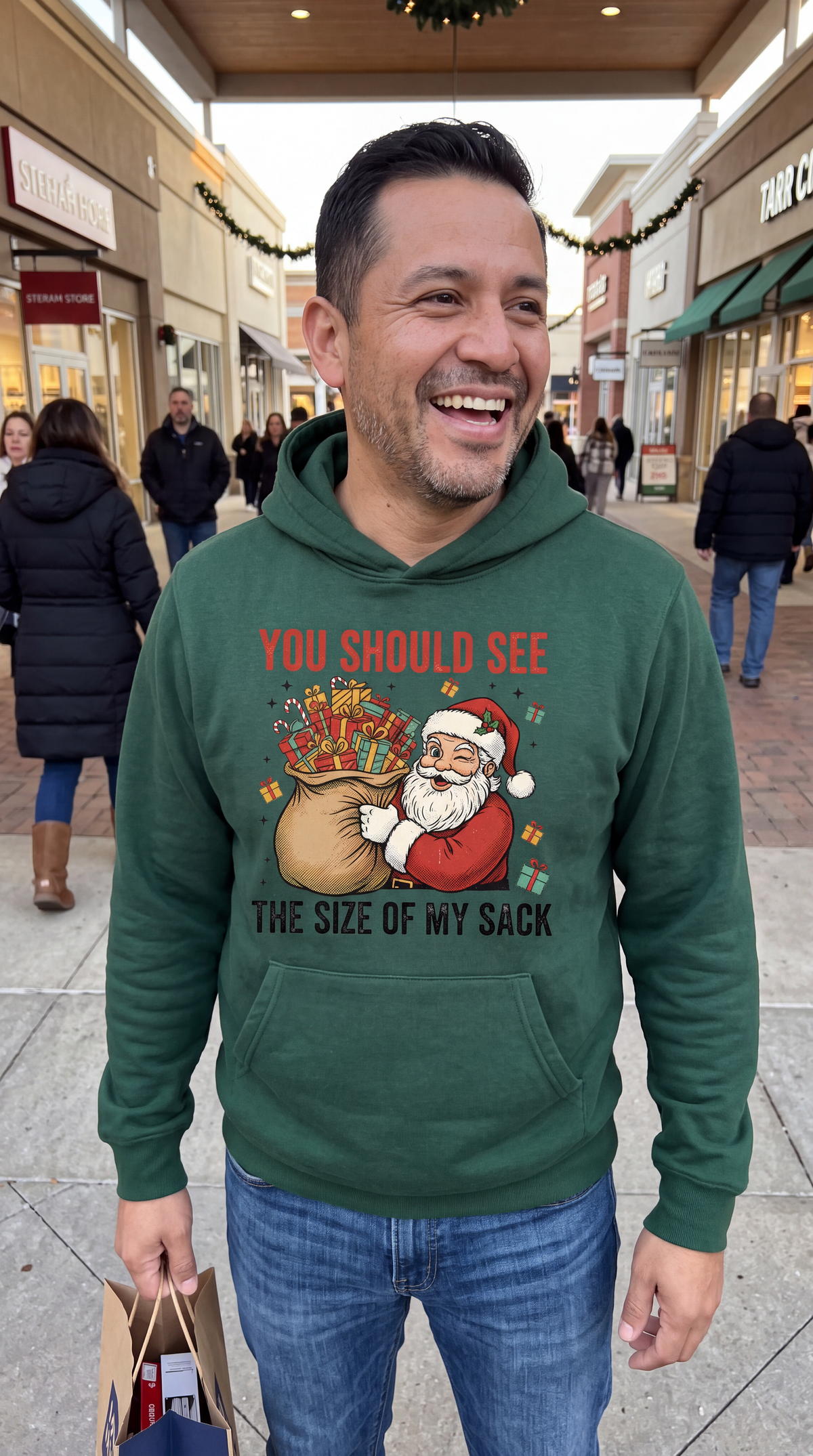 Man wearing forest green funny Santa Christmas hoodie with Size of My Sack design