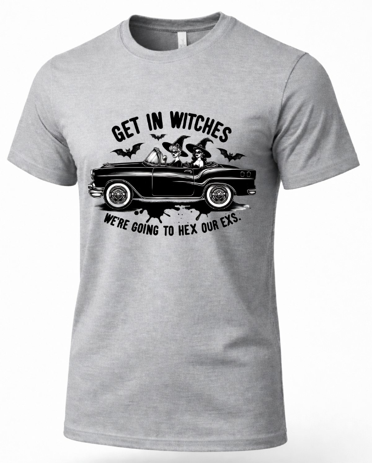 A heather gray short-sleeve crewneck t-shirt with a black graphic print of a witch driving a classic car, accompanied by bats and the text 'GET IN WITCHES WE'RE GOING TO HEX OUR EXS.'.