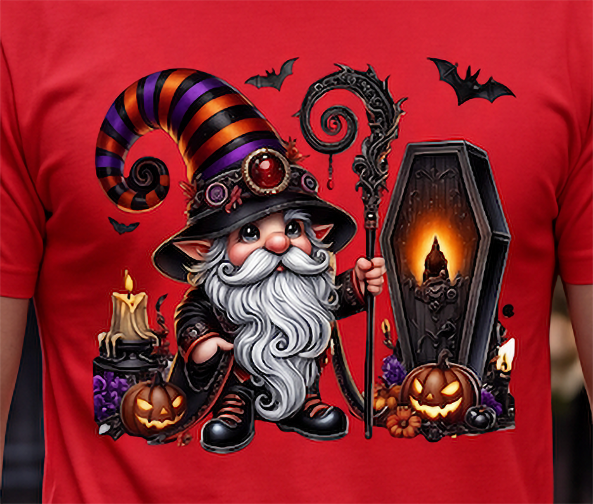 A close-up of a red T-shirt featuring a large Halloween graphic of a wizard gnome with a striped hat, staff, coffin, pumpkins, candles, and bats.