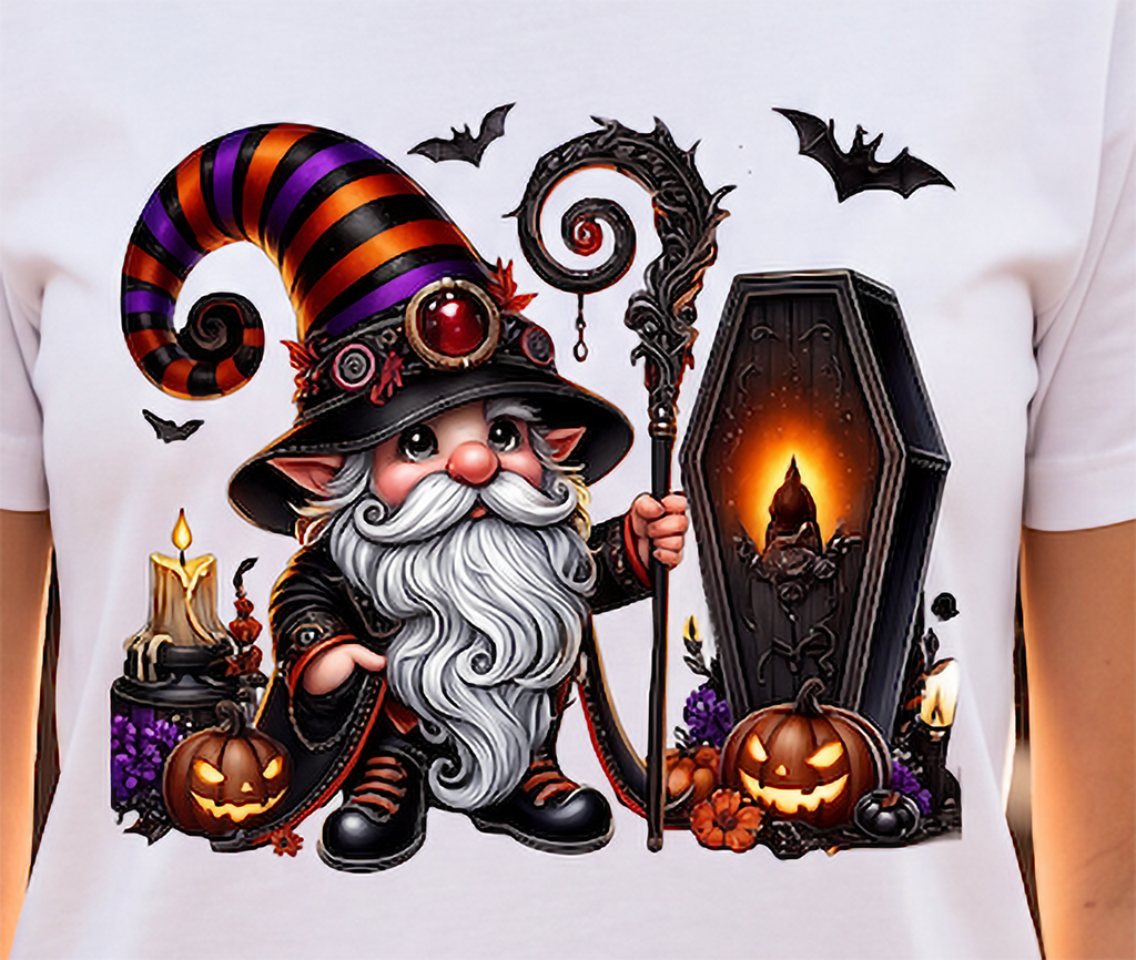 A close-up of a white T-shirt featuring a large, colorful graphic print of a cartoon witch with a striped hat, long white beard, and staff, standing next to a glowing coffin with pumpkins and bats around it.