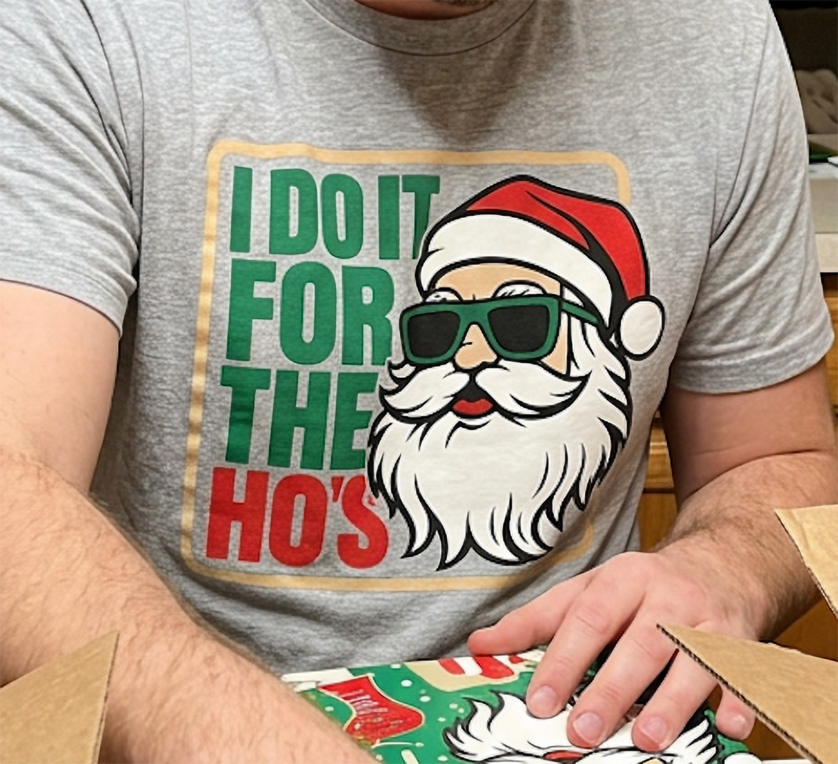 Close-up of Santa sunglasses Christmas graphic printed on a heather gray holiday t-shirt.