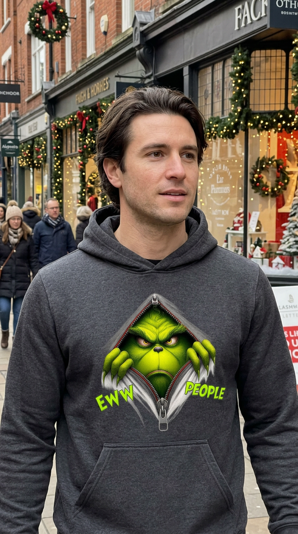 Man wearing gray Eww People Grinch Christmas hoodie at a festive holiday market
