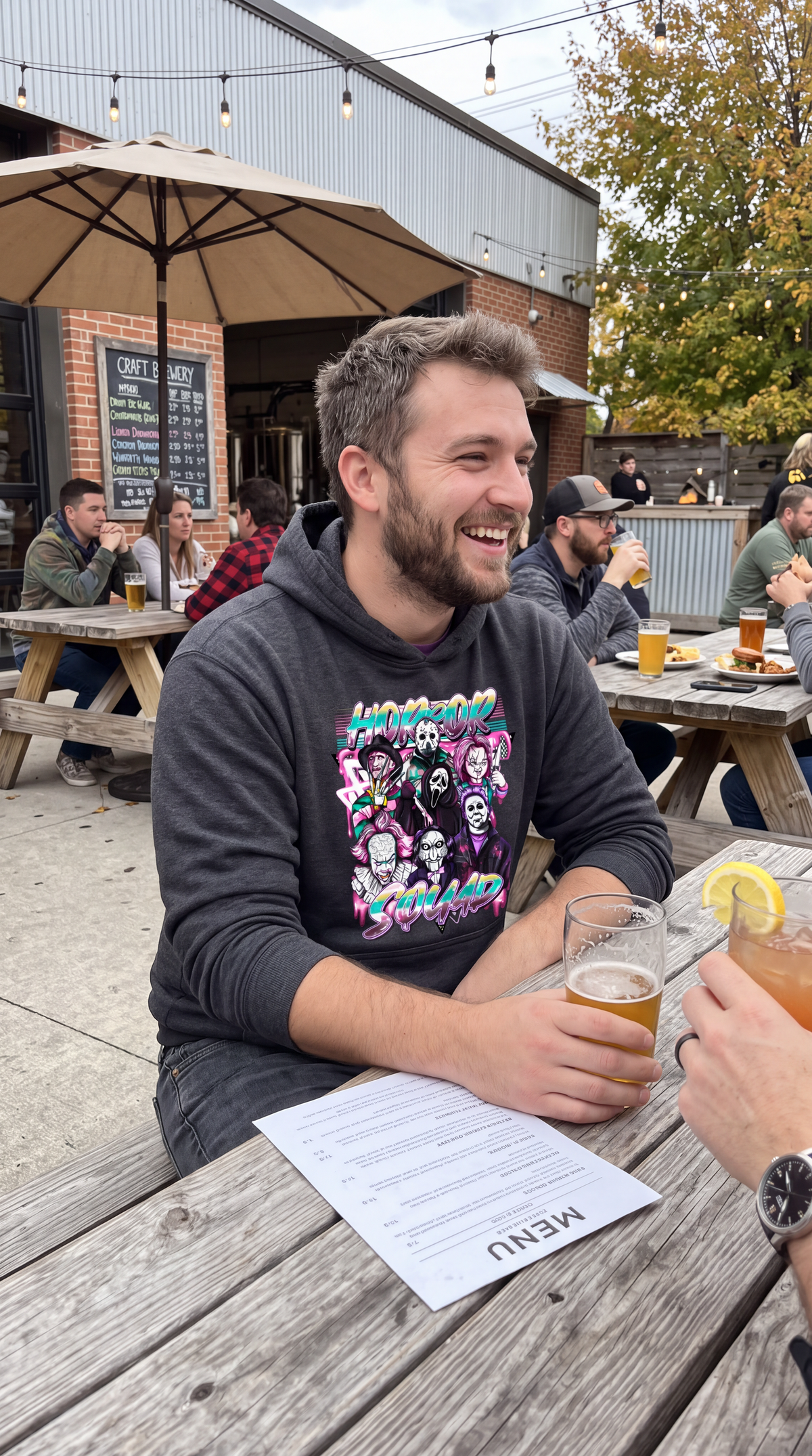Man wearing dark gray Horror Squad hoodie with retro scary movie graphic