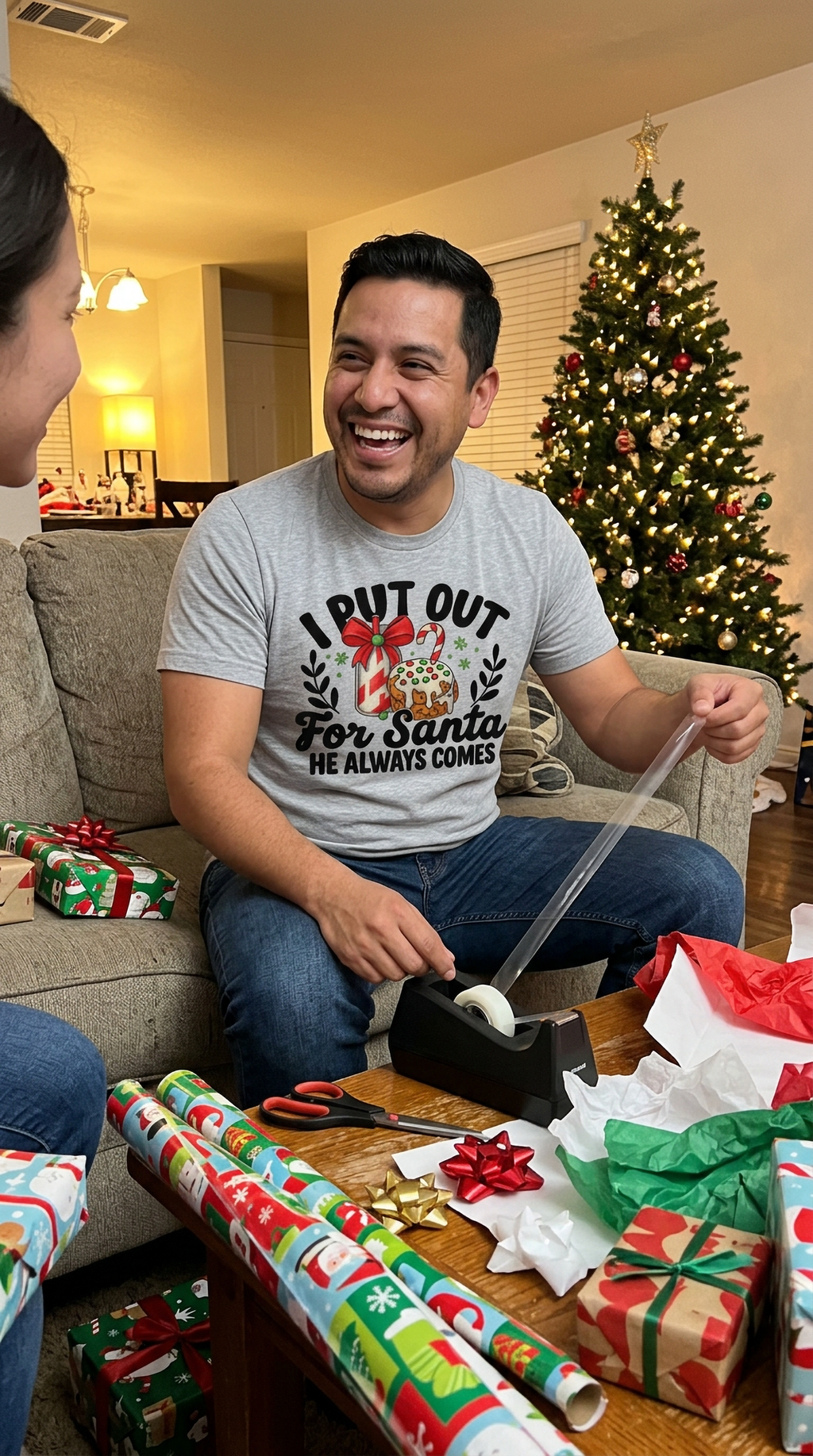 Man wearing heather gray I Put Out for Santa Christmas shirt at a holiday gathering