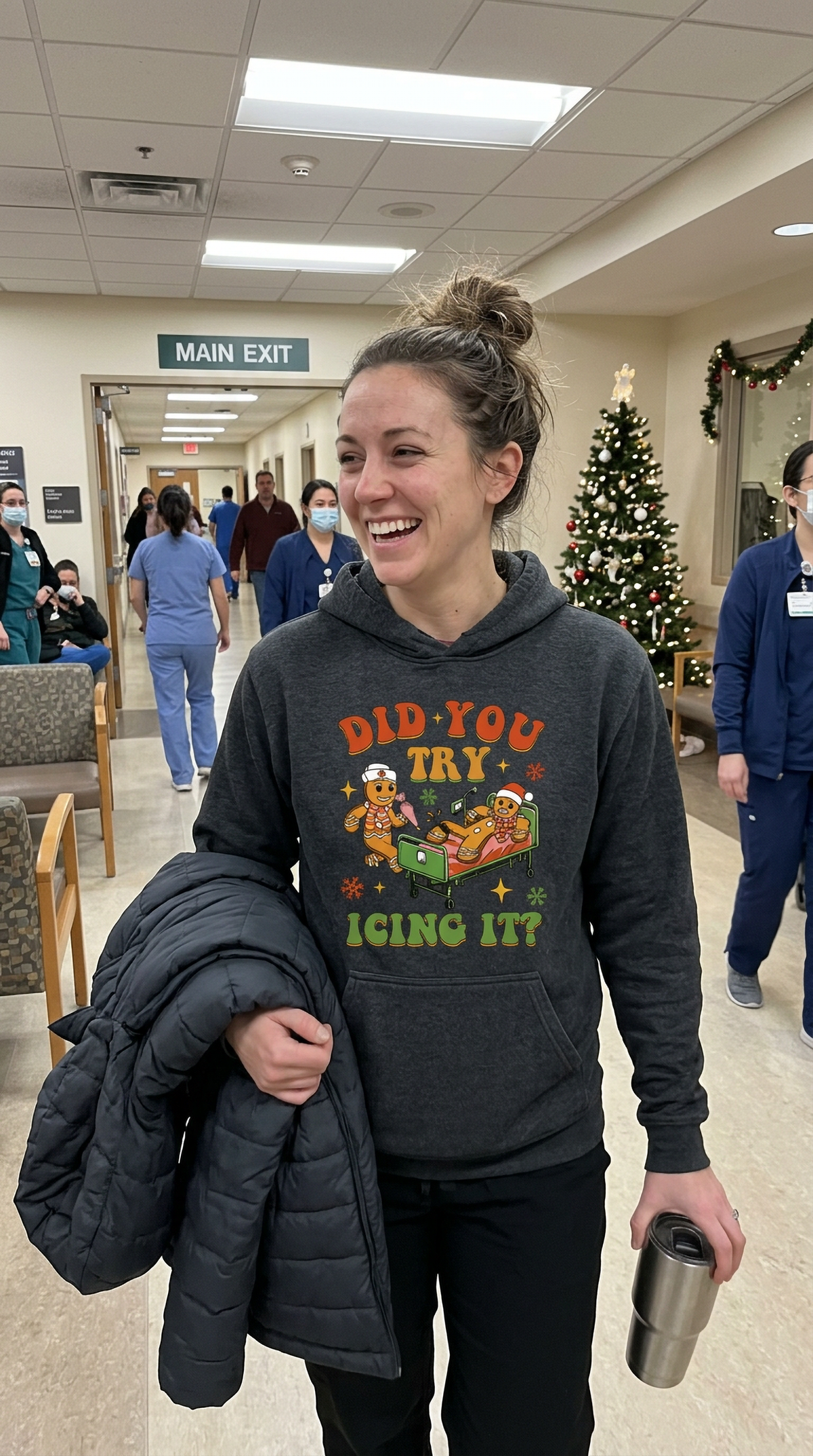 Woman wearing gray Did You Try Icing It Christmas hoodie in a hospital