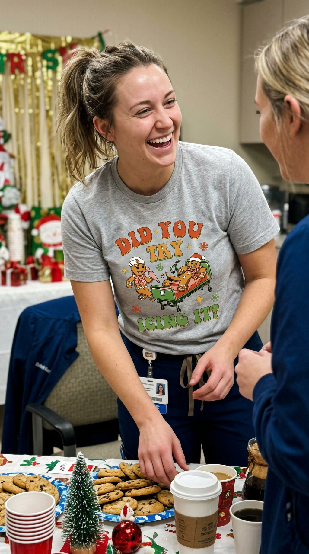 Smiling woman wearing a heather gray Did You Try Icing It Christmas nurse shirt in a festive healthcare workplace.