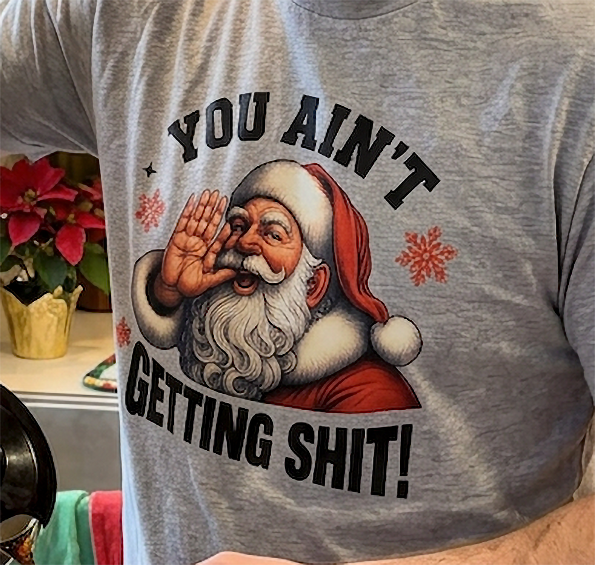 Heather Gray Close-Up: Close-up of vintage Santa Claus artwork and You Ain't Getting Shit Christmas lettering printed on heather gray fabric.