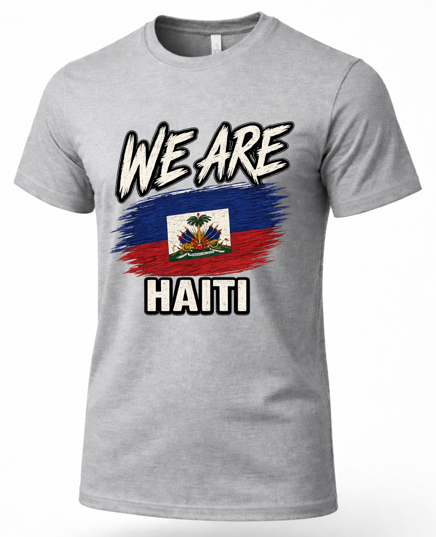 A heather gray short-sleeve t-shirt with a graphic print featuring the Haitian flag and the text 'WE ARE' above and 'HAITI' below, shown on a plain white background.