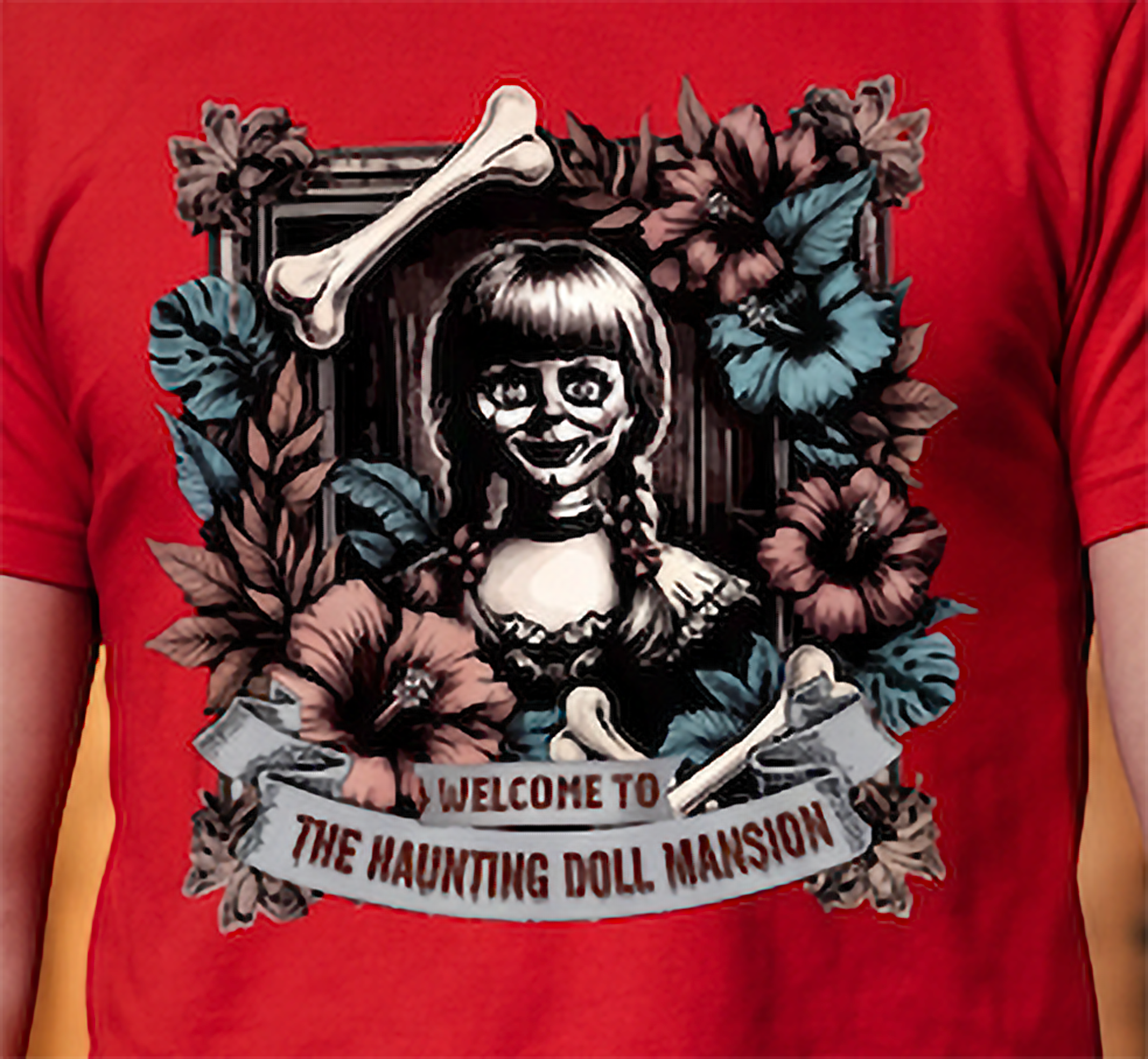 Close-up of creepy haunted doll Halloween graphic on red shirt with floral and bone artwork
