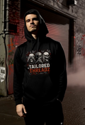 Man wearing black streetwear hoodie with skull graphic in urban alley at night