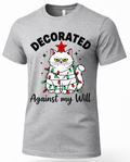 Heather gray Decorated Against My Will Christmas shirt featuring a grumpy white cat wrapped in Christmas lights.