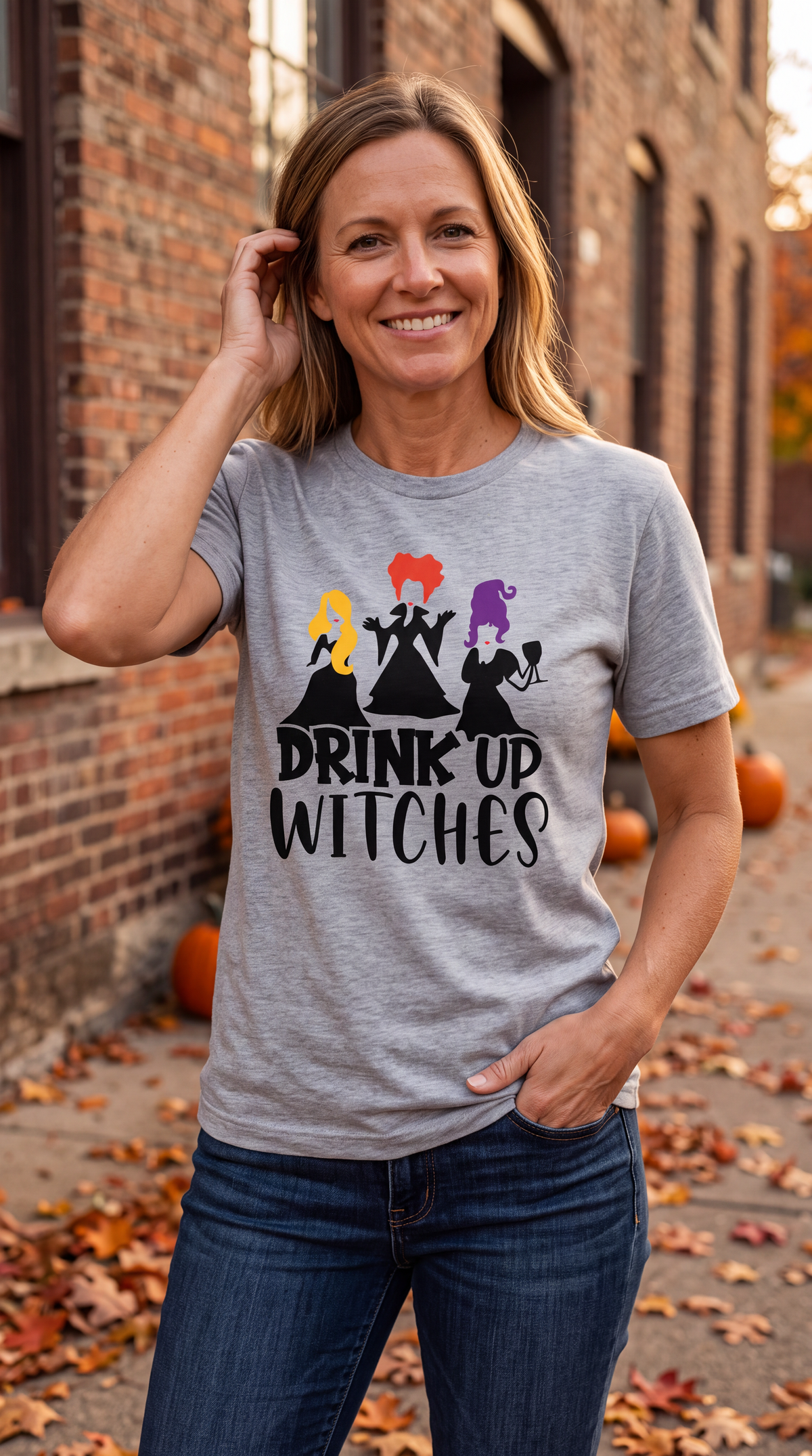 Woman wearing heather gray Drink Up Witches Hocus Pocus Halloween shirt