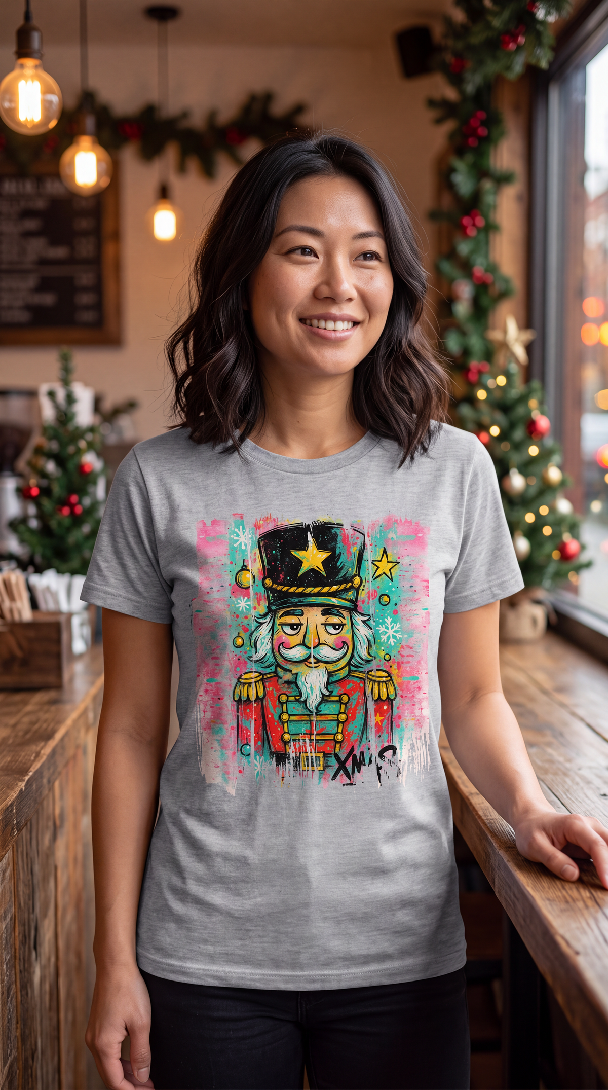 Woman wearing heather gray colorful nutcracker Christmas graphic shirt