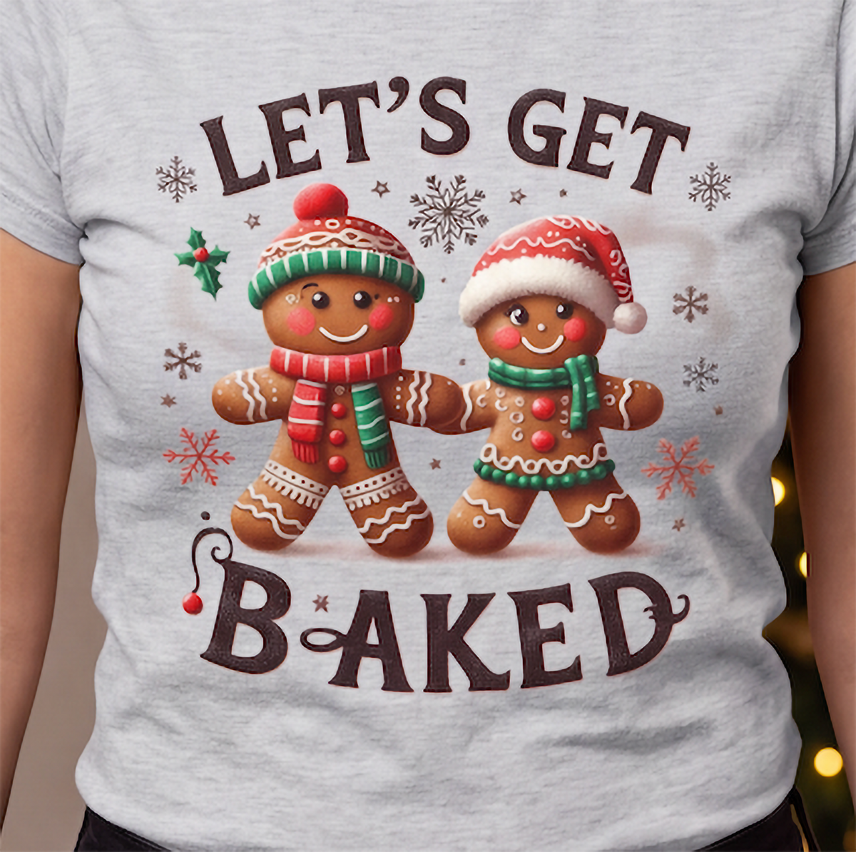 Close-up of Let’s Get Baked gingerbread Christmas graphic printed on gray shirt.