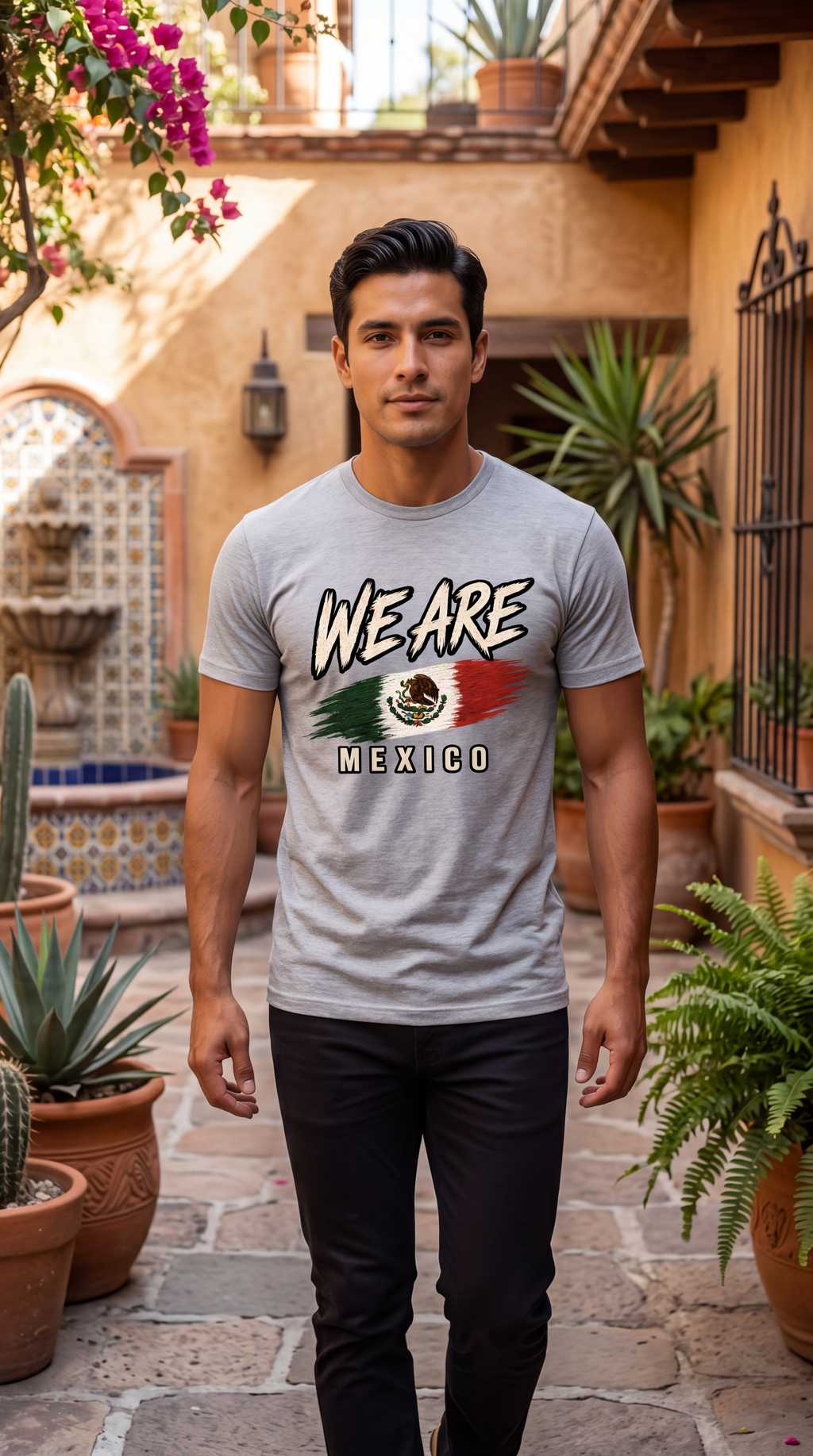 A man wearing a light gray graphic t-shirt with 'WE ARE MEXICO' and the Mexican flag design, standing in a sunny courtyard with potted plants and stone tiles.