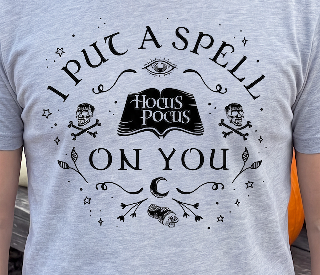 Close-up of heather gray Hocus Pocus Halloween shirt with spellbook design