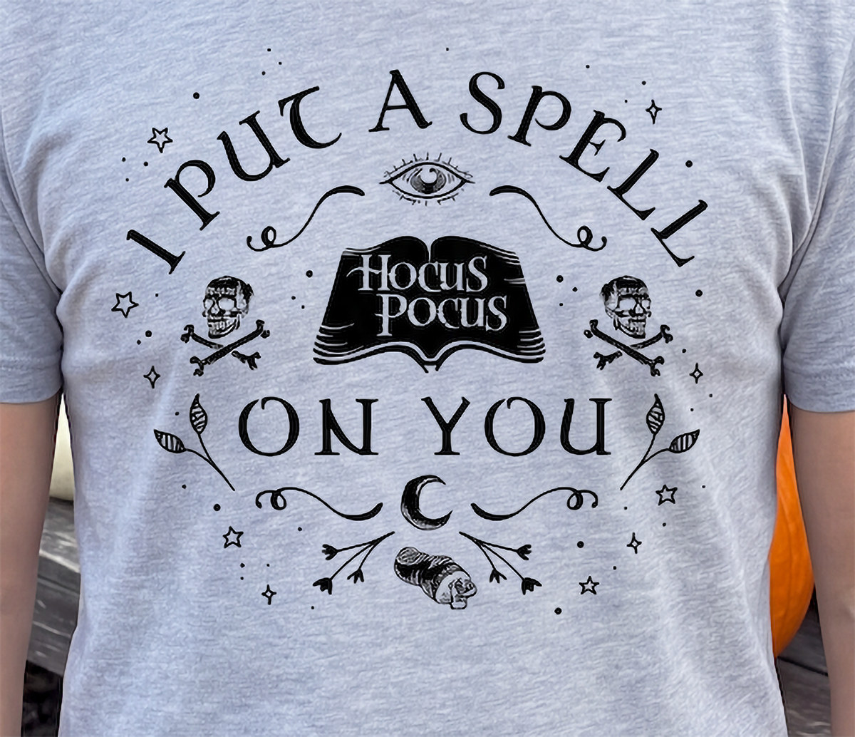 Close-up of heather gray Hocus Pocus Halloween shirt with spellbook design