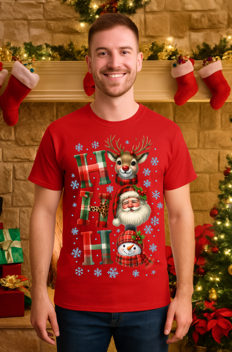 Man wearing a red Ho Ho Ho Christmas t-shirt with Santa, reindeer, and snowman graphic in a festive holiday living room setting.