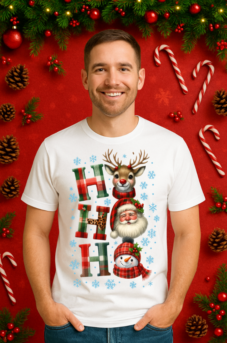Man wearing a white Ho Ho Ho Christmas t-shirt with Santa, reindeer, and snowman graphic in a festive red holiday setting.