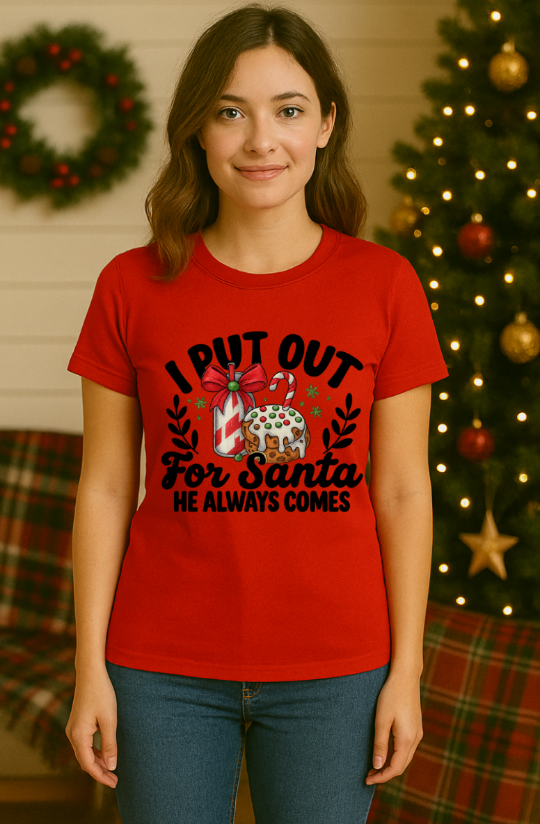 Woman wearing a red Bella + Canvas 3001 unisex t-shirt with “I Put Out for Santa” funny Christmas design, adult humor holiday shirt shown in front of a decorated Christmas tree