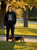 Person wearing hoodie with dog graphic design walking dog outdoors