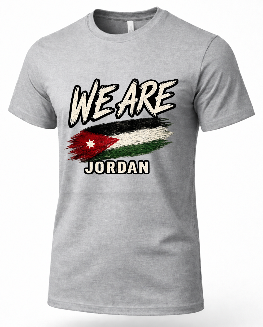 A heather gray short-sleeve t-shirt with a graphic print on the front. The graphic features the text 'WE ARE' in a distressed black-and-white brush font, a stylized distressed flag of Jordan in the center, and 'JORDAN' written below in black block letters with a white outline.