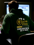 Person wearing green retro LimeWire hoodie with ‘downloaded one song got 47 viruses’ graphic at computer