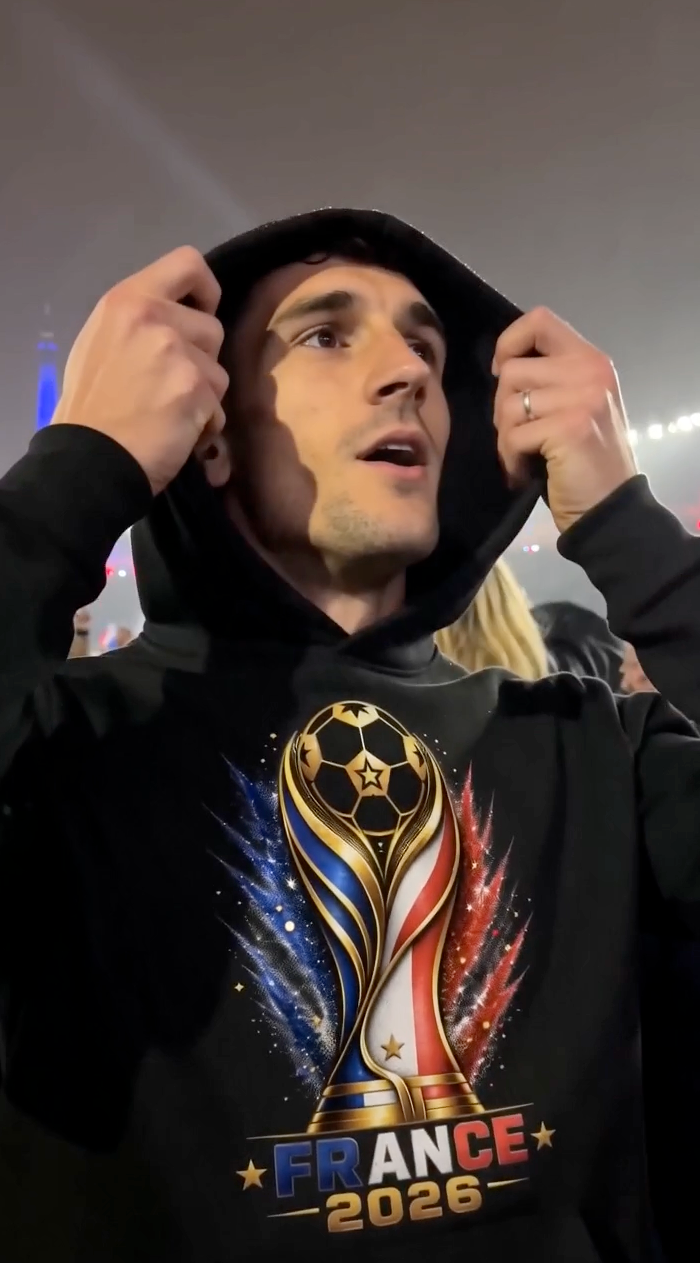 Man wearing black France 2026 soccer hoodie at football stadium with hood up