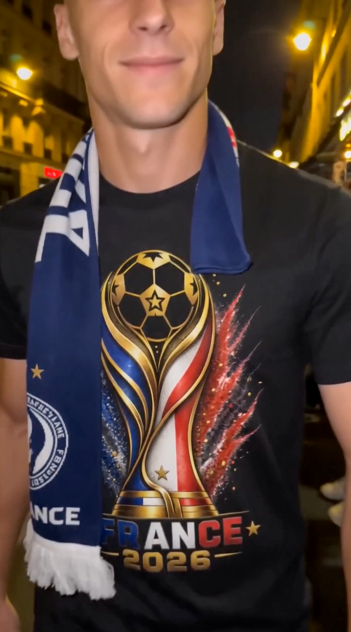 Man wearing black France 2026 soccer shirt with French supporter scarf at night