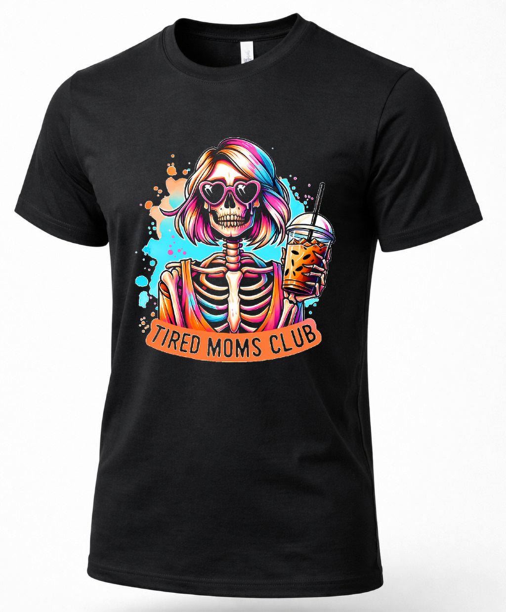 A black short-sleeve crewneck t-shirt featuring a colorful graphic of a skeleton with pink and blue hair, heart-shaped sunglasses, and a drink, with an orange banner reading 'TIRED MOMS CLUB'.