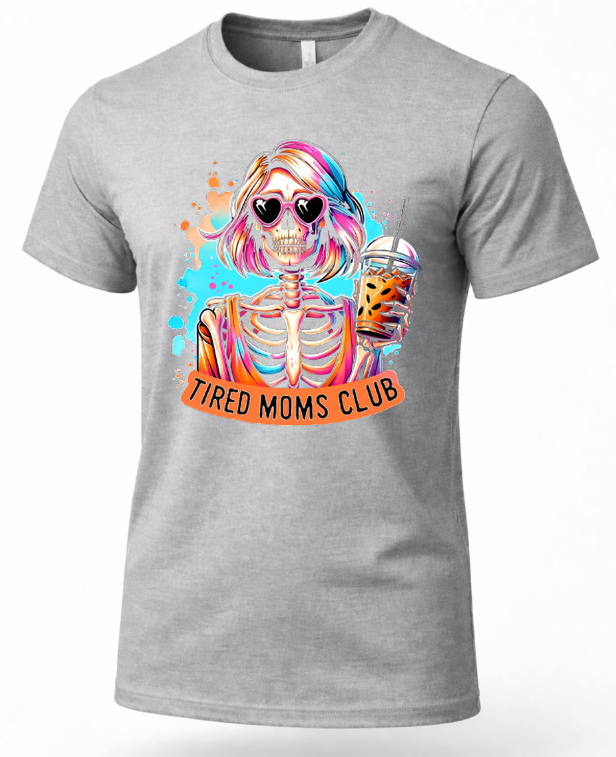 A heather gray short-sleeve crewneck t-shirt featuring a colorful graphic of a skeleton woman with rainbow hair, heart-shaped sunglasses, and a drink, with an orange banner below reading 'TIRED MOMS CLUB'.